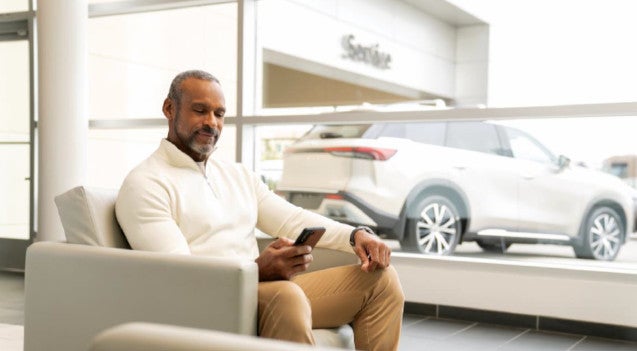 Gentleman looking at phone in INFINITI service center
